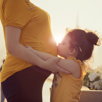 Kid,Kissing,The,Belly,Of,Her,Mom